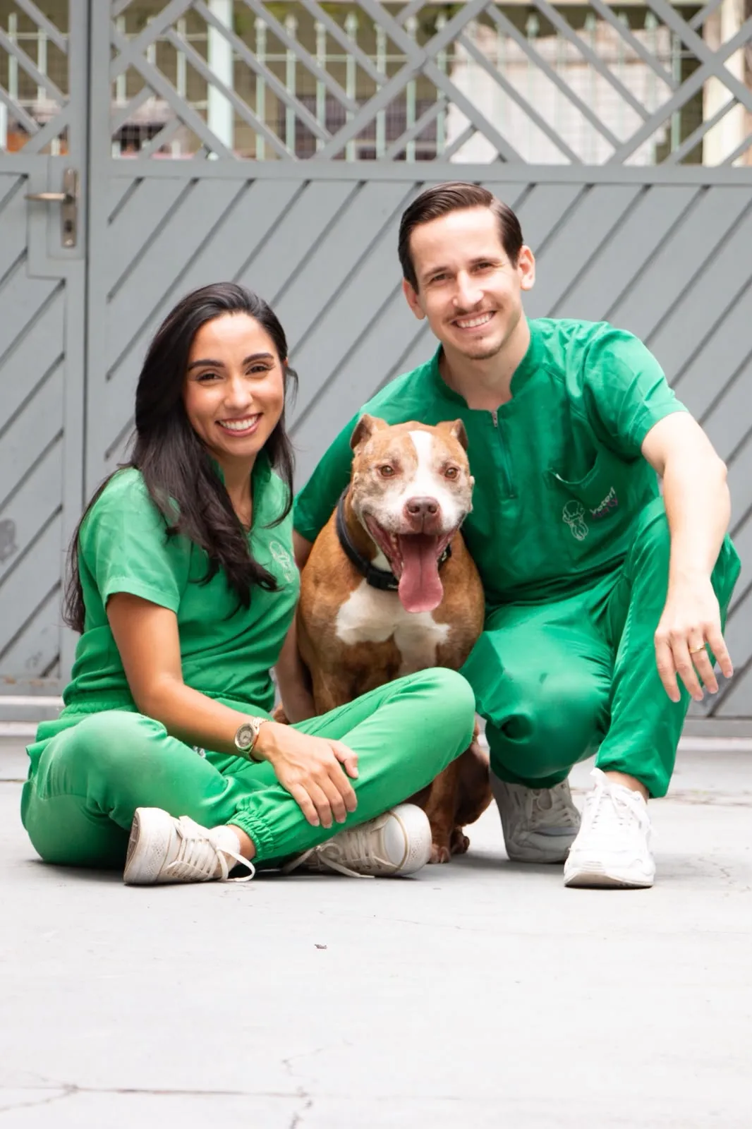 Natália e Bruno Gondim com um pitbull durante atendimento domiciliar