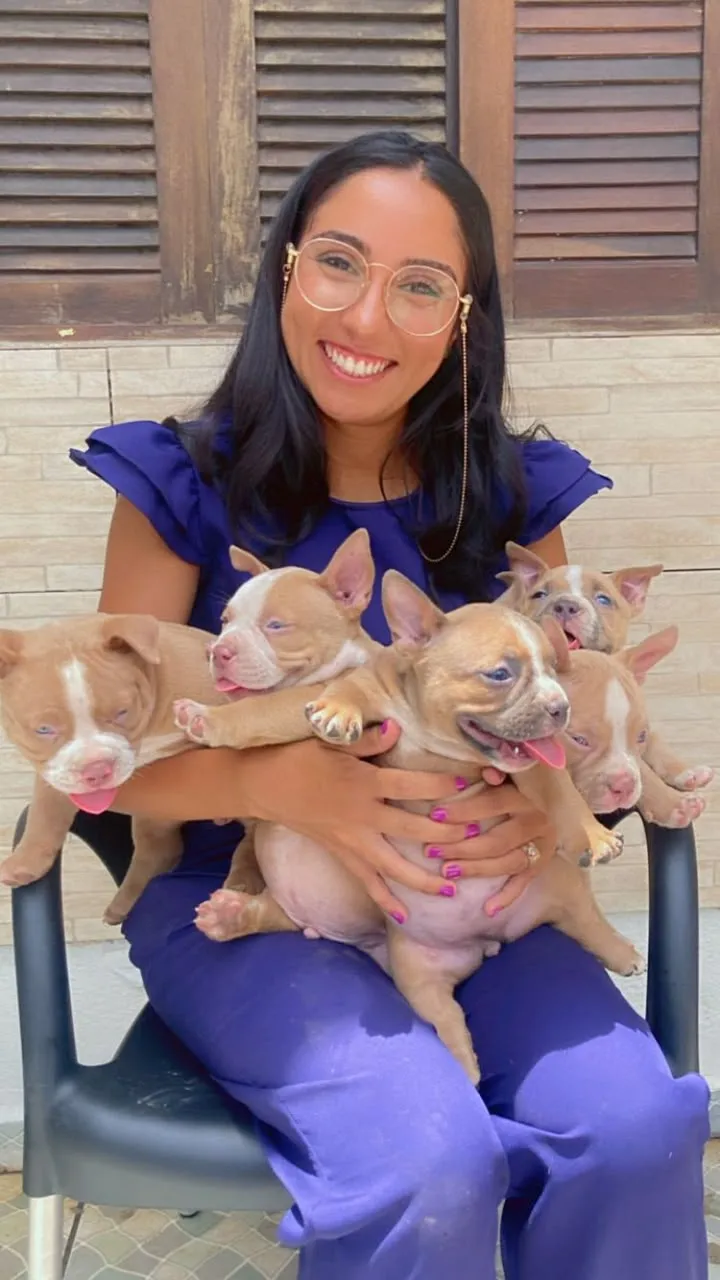 Dra. Natália com uma ninhada de filhotes no colo