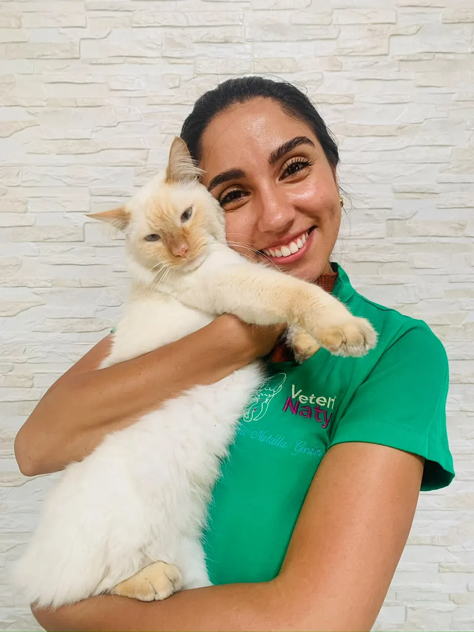 Dra. Natália com um gato branco no colo