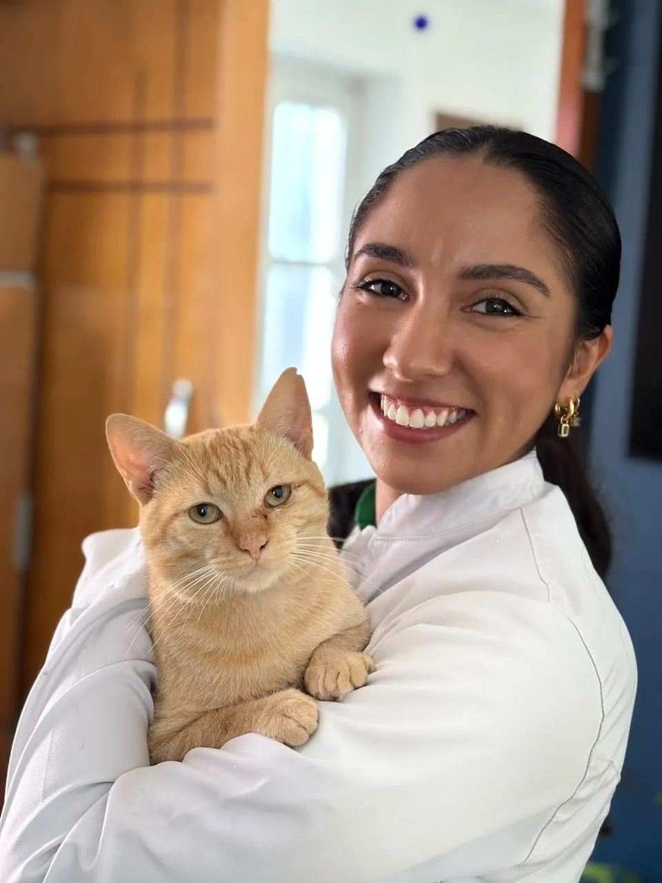 Dra. Natália com um gato laranja no colo