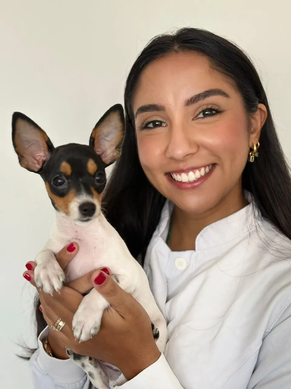 Dra. Natália segurando um pinscher filhote